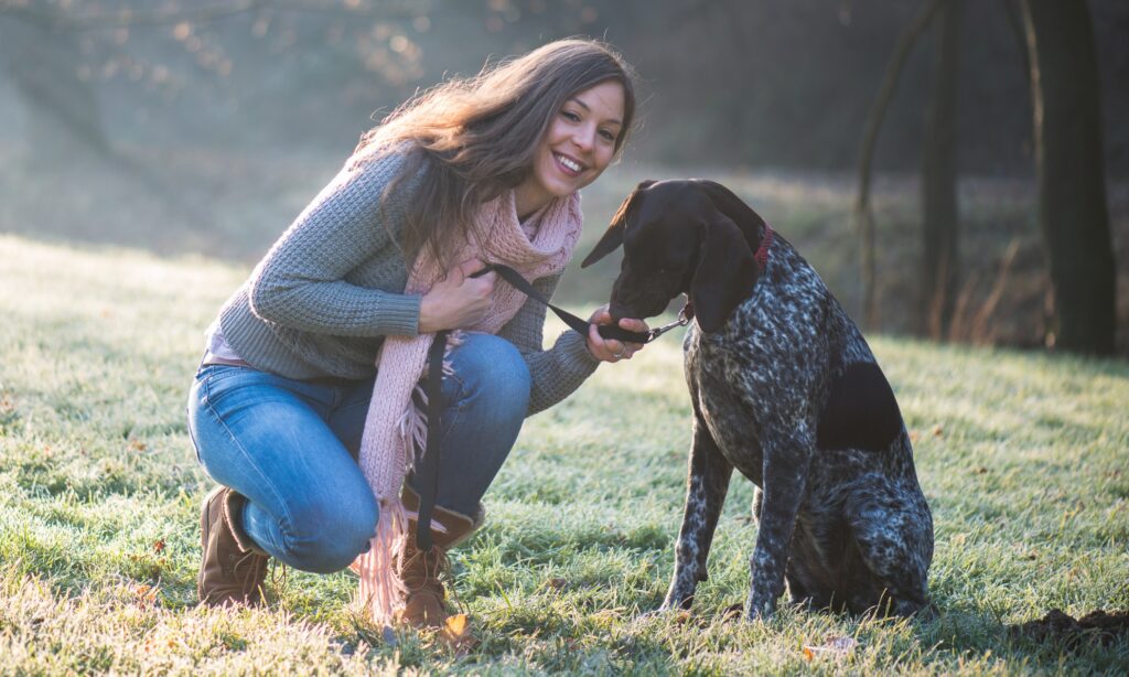 Female dog trainer training a dog in the park